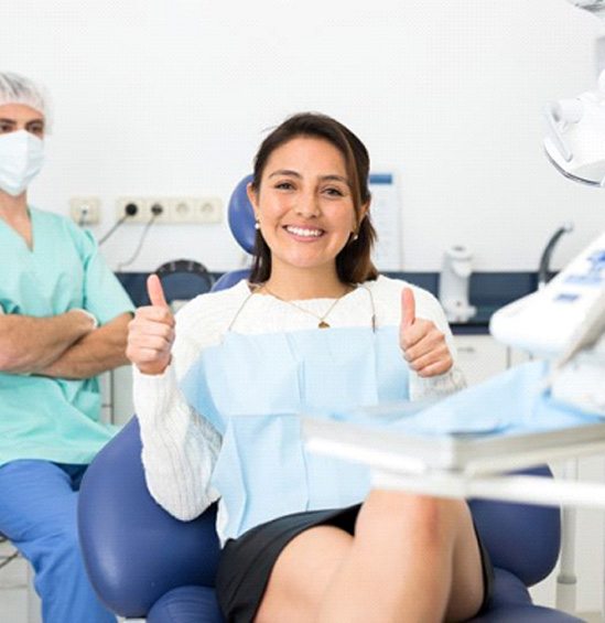 Happy dental patient giving two thumbs up