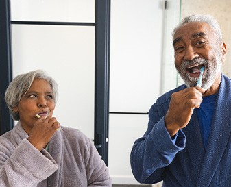 Two people brushing their teeth together