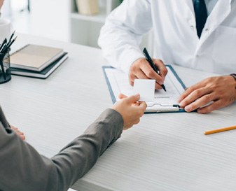 Person paying doctor for dental implants