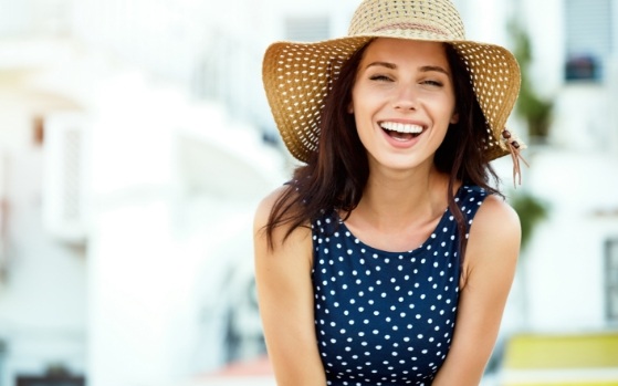 Woman in sunhat smiling after cosmetic dentistry in Fresno