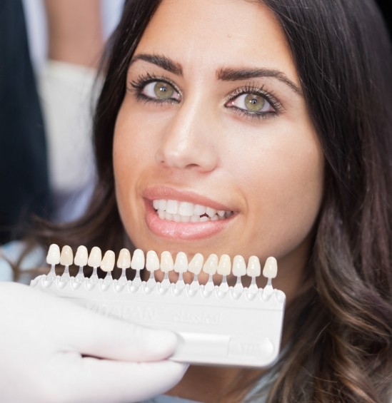 Cosmetic dentist fitting a patient with dental veneers