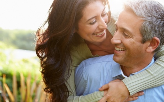 Man and woman smiling at each other with dental implants in Fresno