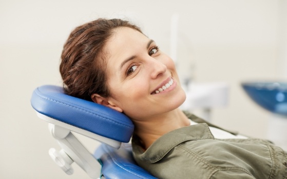 Smiling woman leaning back in dental chair