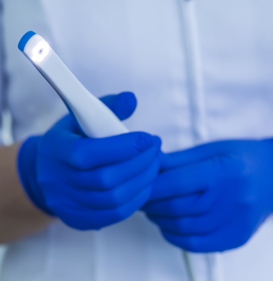 Dentist holding thin white intraoral camera