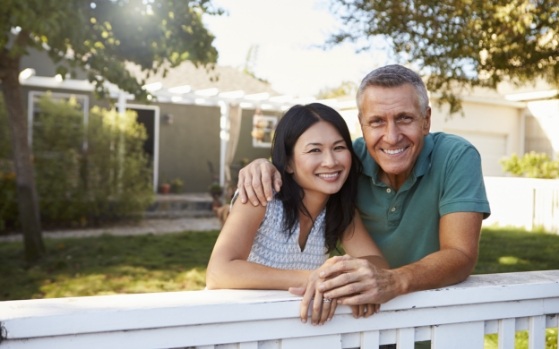 SMiling man and woman standing in their front yard