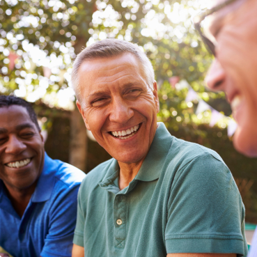 Man laughing outdoors with two friends after visiting dentist in Fresno California