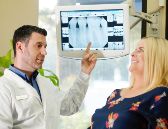 Doctor Jake showing a patient an x ray of their teeth