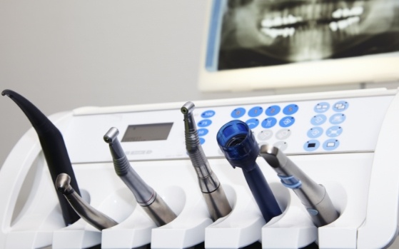 Row of dental instruments with x ray of teeth in background in Fresno dental office