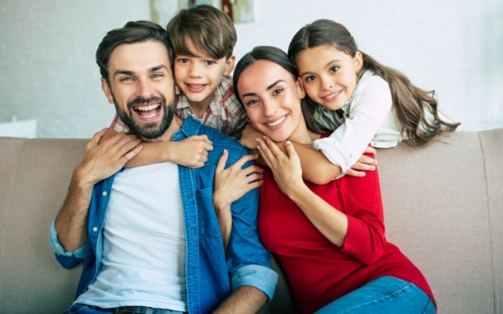 Smiling family of four sitting on couch