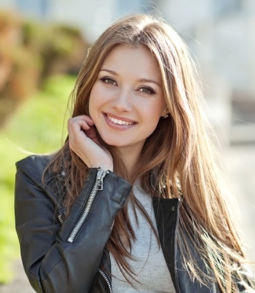 Young brunette woman smiling outdoors