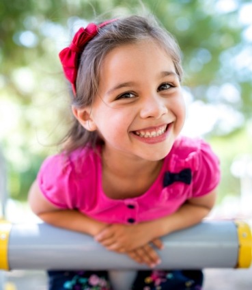Young girl in pink shirt grinning