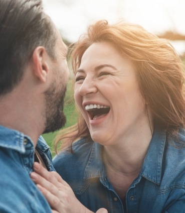 Woman laughing with man outdoors