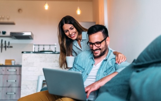 Man and woman looking at laptop for dentist reviews in Fresno