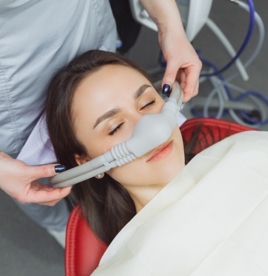 Woman in dental chair with nitrous oxide sedation mask over her nose