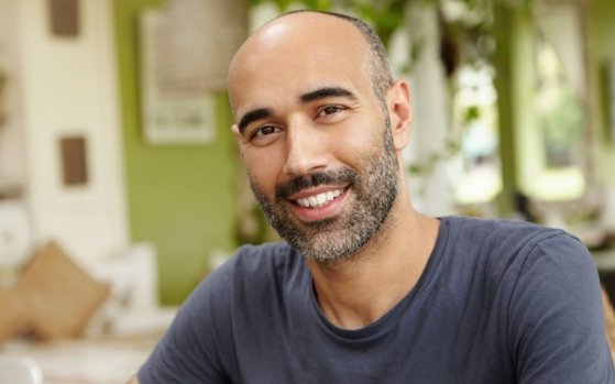 Man in gray shirt smiling after T M J treatment in Fresno