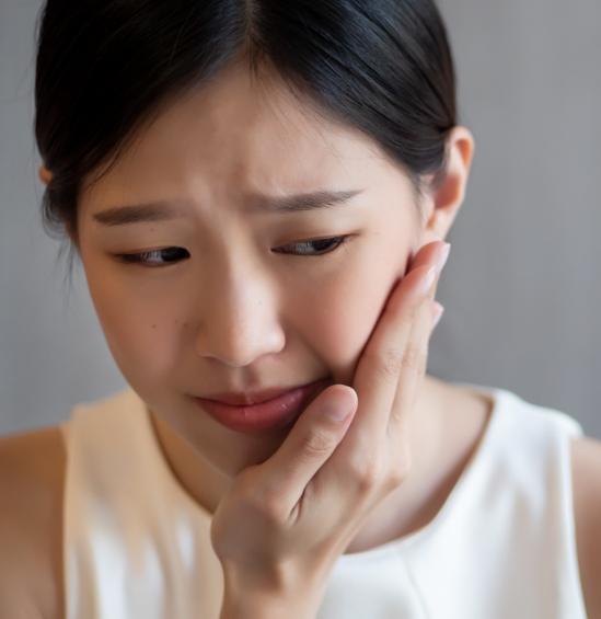 Woman holding the side of her face in pain