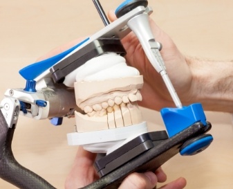 Dentist holding model of jaws inside of adjustment device