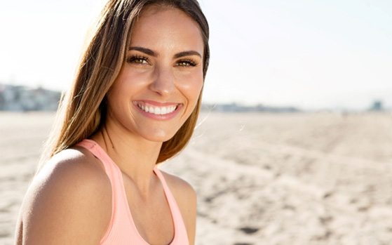 Woman with white teeth smiling on beach