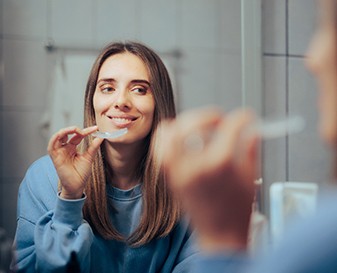 Woman using at-home teeth whitening in Fresno